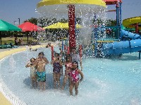 Students under sprinkler umbrella at water park